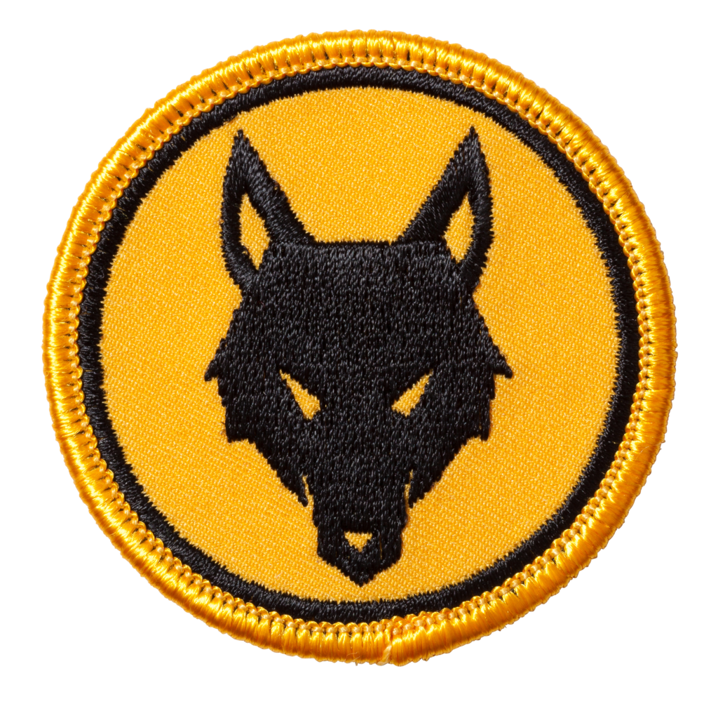 Das Wappen der Meutenstufe: Ein schwarzer Wolfskopf auf gelbem Hintergrund.